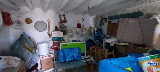 Interior of a rustic rural property in Oria, Almeria, filled with various household items and storag.