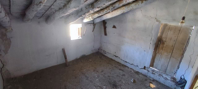 Interior of rustic rural property in Oria, Almeria with unfinished walls and small window.