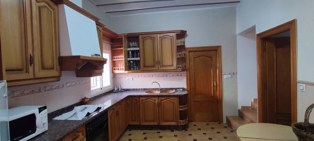 Traditional Spanish kitchen with wooden cabinets and modern appliances in rural Oria, Almeria.