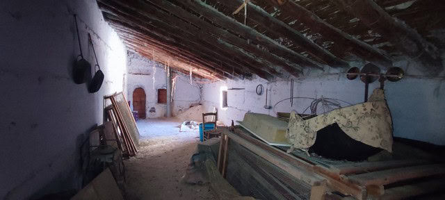 Interior view of a rustic rural property in Oria, Almeria, showing an unfinished attic space with wo.