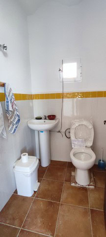 Bathroom with white fixtures and small window.