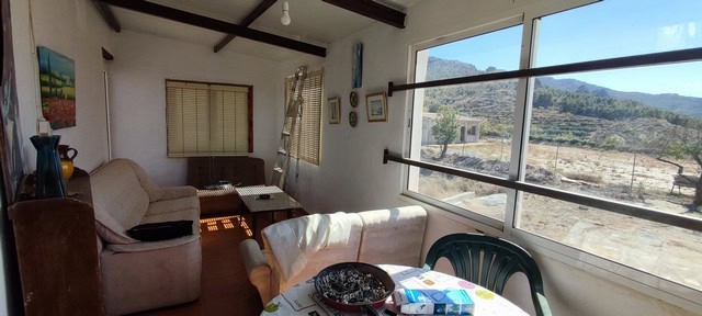 Charming rural home interior with large windows overlooking scenic countryside in Tijola, Almeria.