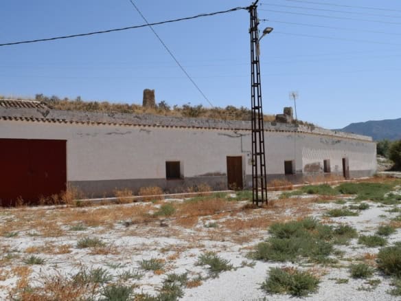 Cave house in El Margen, Granada, with traditional white walls and rustic surroundings. Perfect for.