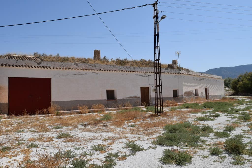 Cave house in El Margen, Granada, with traditional white walls and rustic surroundings. Perfect for.