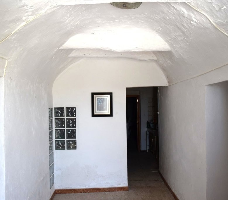 Traditional cave house interior in El Margen, Granada, showcasing whitewashed walls and arched ceili.