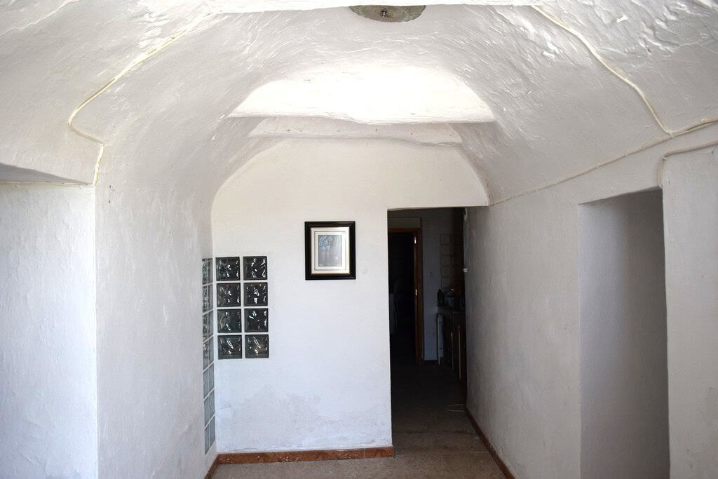 Traditional cave house interior in El Margen, Granada, showcasing whitewashed walls and arched ceili.