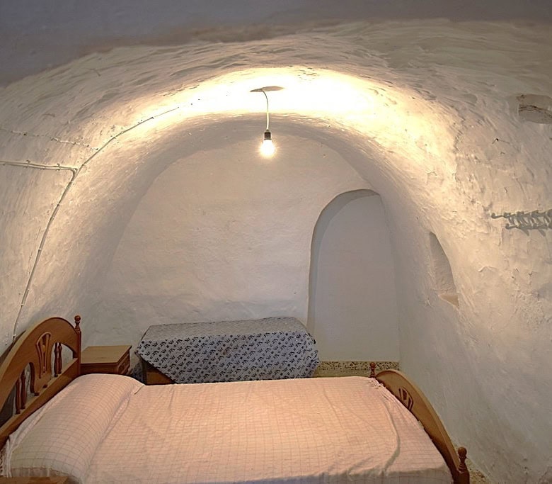 Cave house interior in El Margen, Granada with rustic stone walls and cozy bedroom. Unique undergrou.