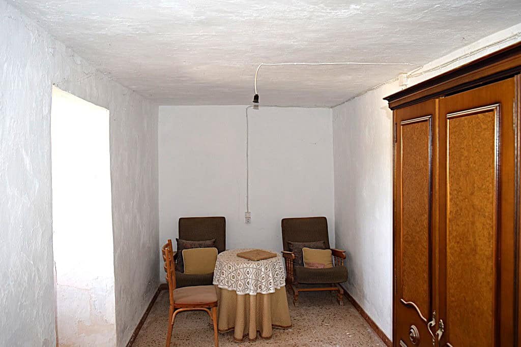 Interior view of a rustic cave house with vintage furniture in El Margen, Granada.