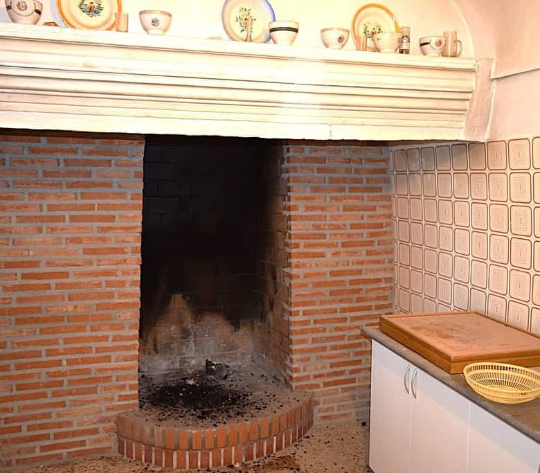 Traditional cave house fireplace in El Margen, Granada, with brick construction and rustic charm.