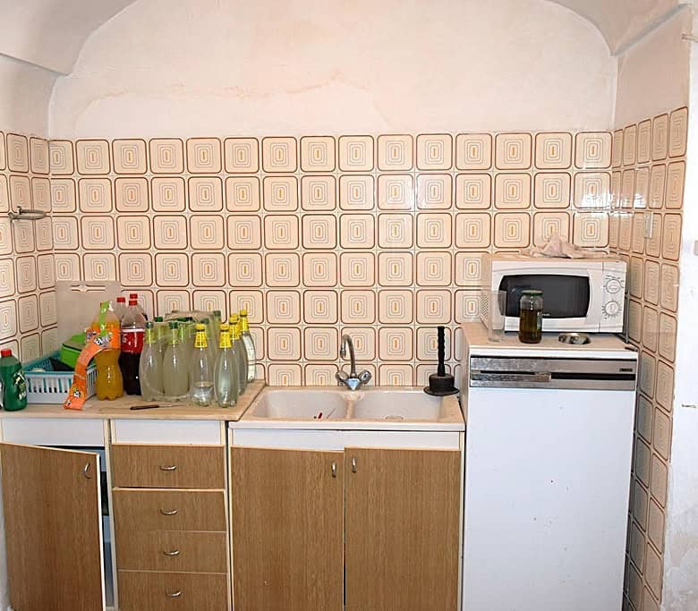 Charming cave house kitchen in El Margen, Granada, featuring basic appliances and rustic decor.