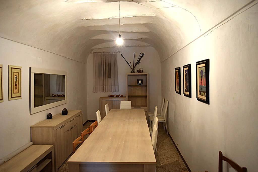 Cave house interior with a dining table, chairs, and cozy decor in El Margen, Granada.