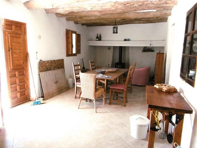 Charming rural home interior with rustic wooden beams and cozy dining area in Hijate, Almeria.