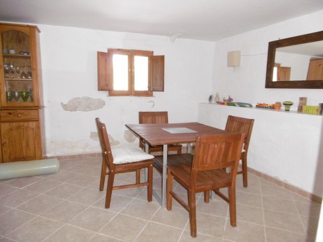 Charming interior of a rural property in Hijate, Almeria, featuring a cozy dining area with wooden f.