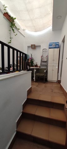 Interior view of a cozy town house in Tijola, Almeria, featuring a skylight, staircase, and simple f.