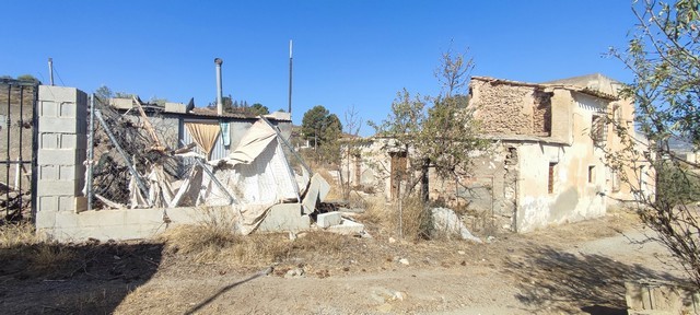 Traditional rural house in Olula del Rio, Almeria, with rustic stone walls and surrounding land.