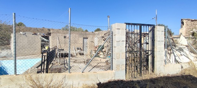 Rural property in Olula del Rio, Almeria, featuring a partially built structure with fencing and out.
