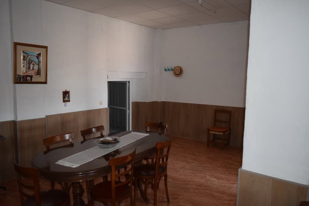 Charming interior of a cave house in Castillejar, Granada, featuring a dining area with wooden furni.