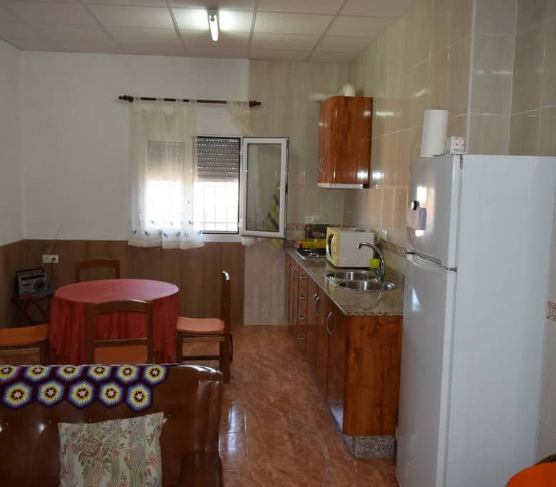 Charming cave house interior in Castillejar, Granada, featuring a small kitchen and dining area.