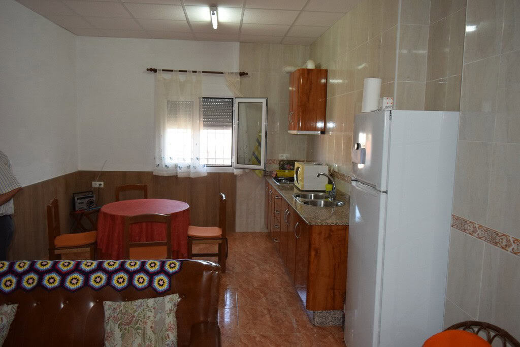 Charming cave house interior in Castillejar, Granada, featuring a small kitchen and dining area.