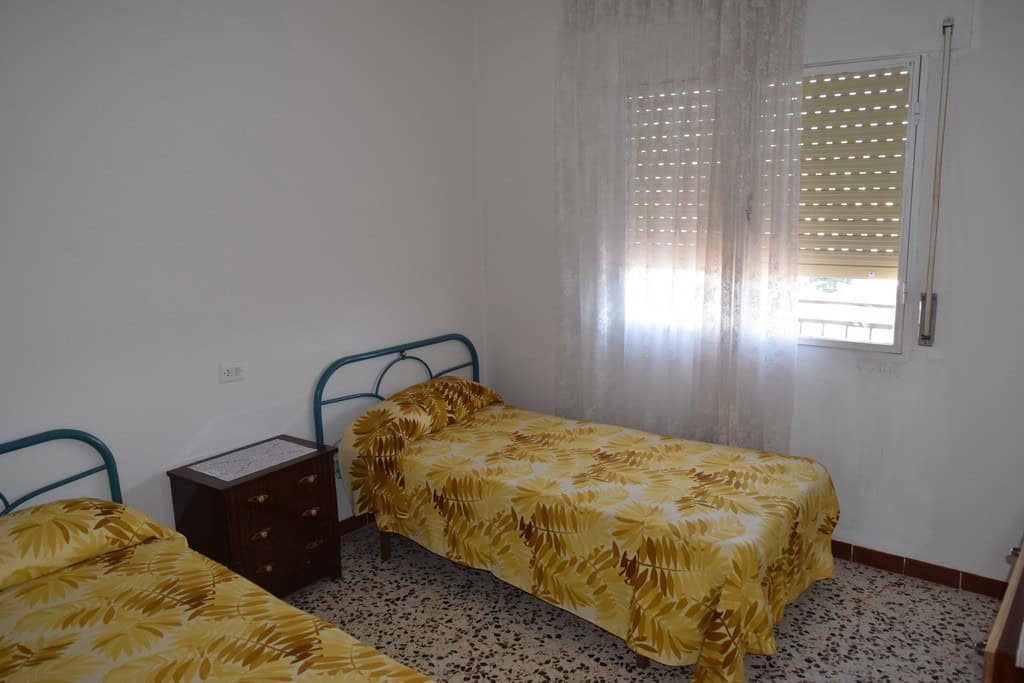 Cave house bedroom in Castillejar, Granada with two single beds and natural light.