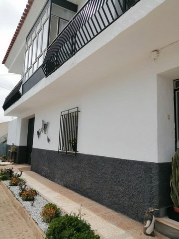 Charming village property in Las Vertientes, Granada, featuring a white exterior and black accents,.
