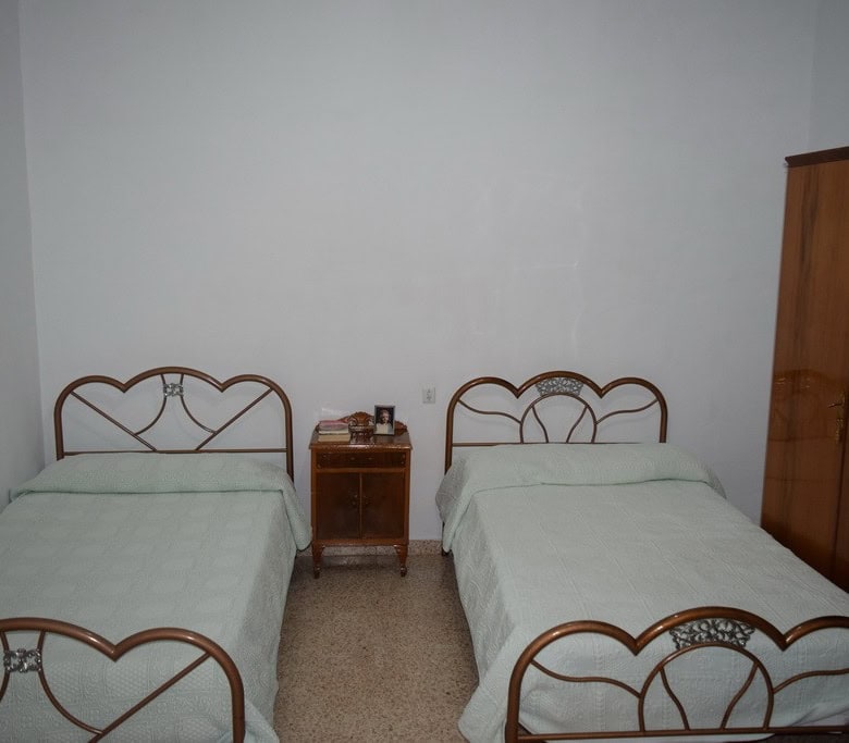 Village property bedroom with two single beds and wooden furniture in Cortes de Baza, Granada.