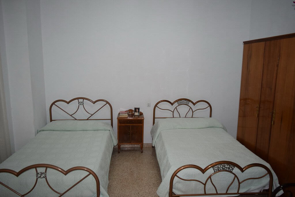 Village property bedroom with two single beds and wooden furniture in Cortes de Baza, Granada.