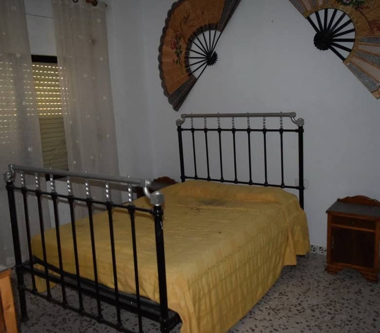 Charming bedroom in a village property located in Cortes de Baza, Granada, featuring a metal bed fra.