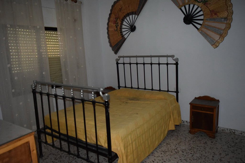 Charming bedroom in a village property located in Cortes de Baza, Granada, featuring a metal bed fra.