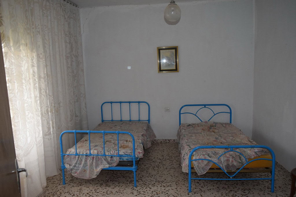 Charming bedroom with two blue metal beds in a rural village property in Cortes de Baza, Granada.