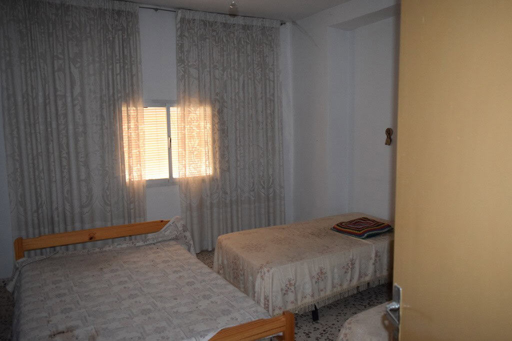 Bedroom with two single beds and lace curtains in Cortes de Baza village, Granada.