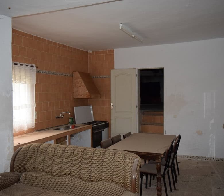 Interior of village property in Cortes de Baza, Granada, featuring a simple kitchen and dining area.