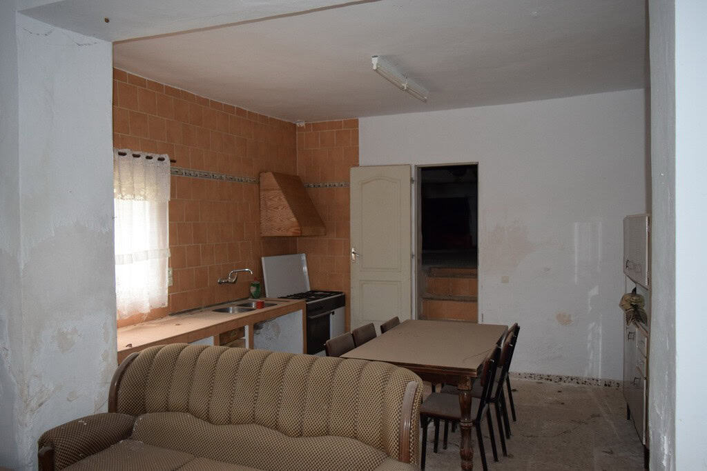 Interior of village property in Cortes de Baza, Granada, featuring a simple kitchen and dining area.