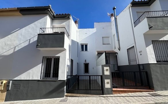 Modern town house in Caniles, Granada with white exterior and balconies.