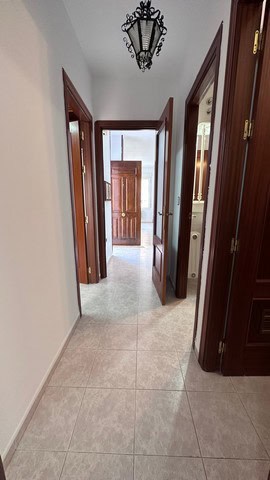 Interior view of a town house hallway in Caniles, Granada, featuring wooden doors and a decorative c.