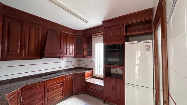 Beautiful kitchen in a town house in Caniles, Granada, featuring wooden cabinets and modern applianc.