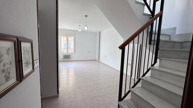 Interior view of a town house in Caniles, Granada, showcasing a spacious living area with staircase.