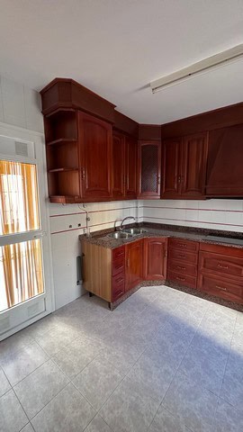 Kitchen of a town house in Caniles, Granada with wooden cabinets and modern fixtures.