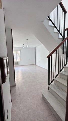 Interior view of a town house in Caniles, Granada, showcasing a spacious living area with staircase.
