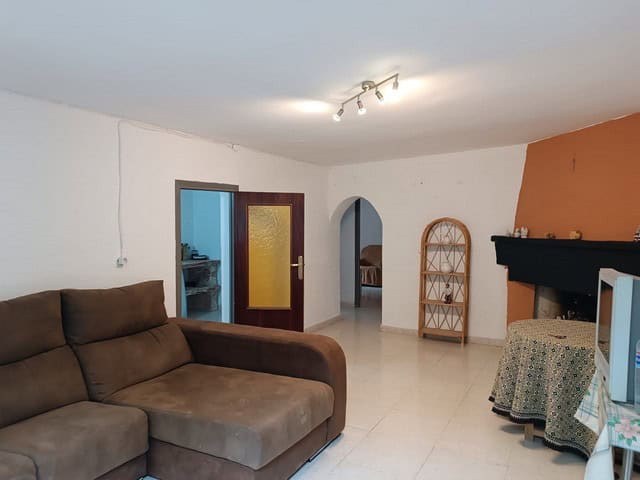 Spacious living room of a rural property in Baza, Granada, featuring a cozy sofa and traditional fir.