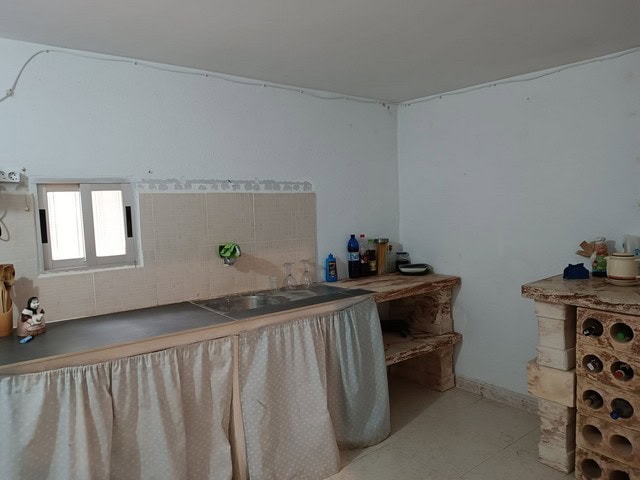 Rustic kitchen in rural property near Baza, Granada with simple furnishings and natural light.