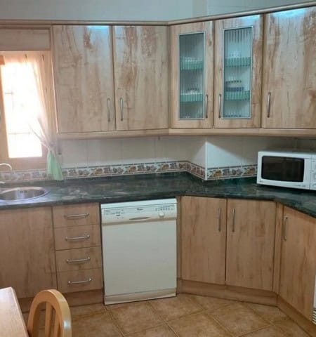 Kitchen with wooden cabinets and modern appliances in Cullar, Granada.