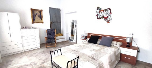 Cozy bedroom in Albanchez village property, featuring a large bed, modern furniture, and decorative.