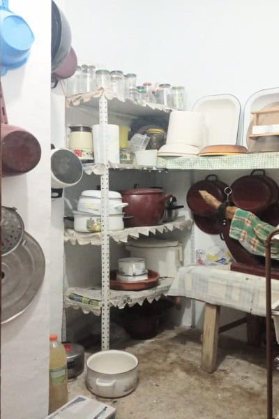 Spacious kitchen storage with shelves holding dishes, pots, and kitchenware in a village property in.
