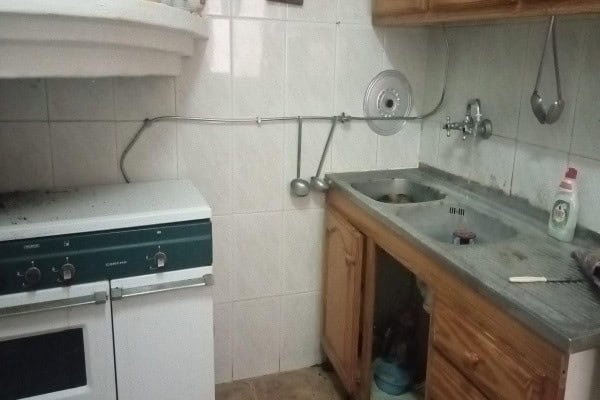 Cozy village kitchen with basic appliances and rustic wooden cabinets in Hinojares, Jaen.