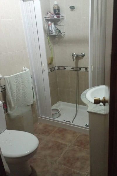 Compact bathroom with shower, toilet, and sink in a village property in Hinojares, Jaen.