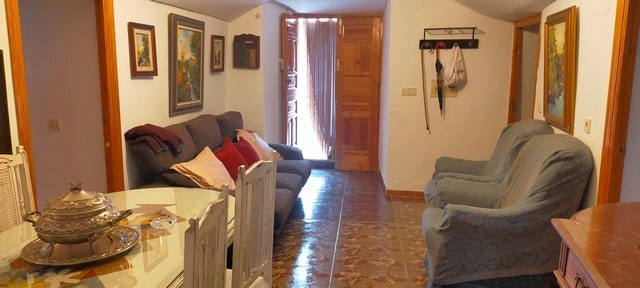 Cozy interior of a traditional cave house in Benamaurel, Granada, featuring rustic decor and comfort.