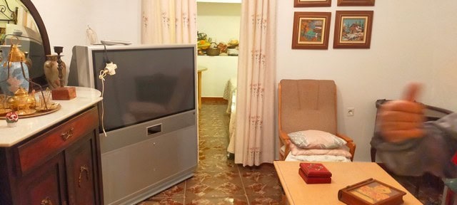 Interior view of a traditional cave house in Benamaurel, Granada, showcasing rustic furniture and co.