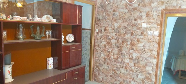 Interior view of a village property in Benamaurel, Granada, showcasing a wooden cabinet and exposed.