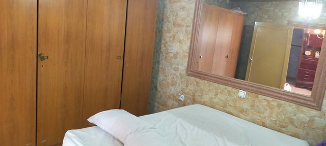 Cozy bedroom in a village property located in Benamaurel, Granada, featuring wooden wardrobes and ru.